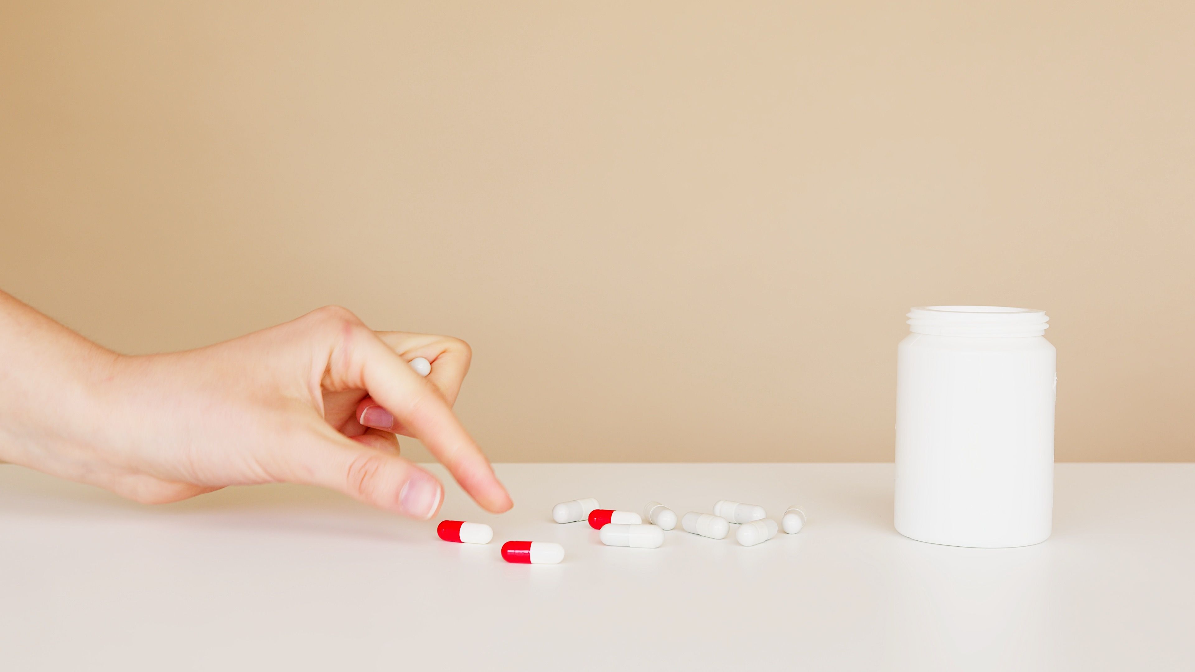 Patient taking pill from table