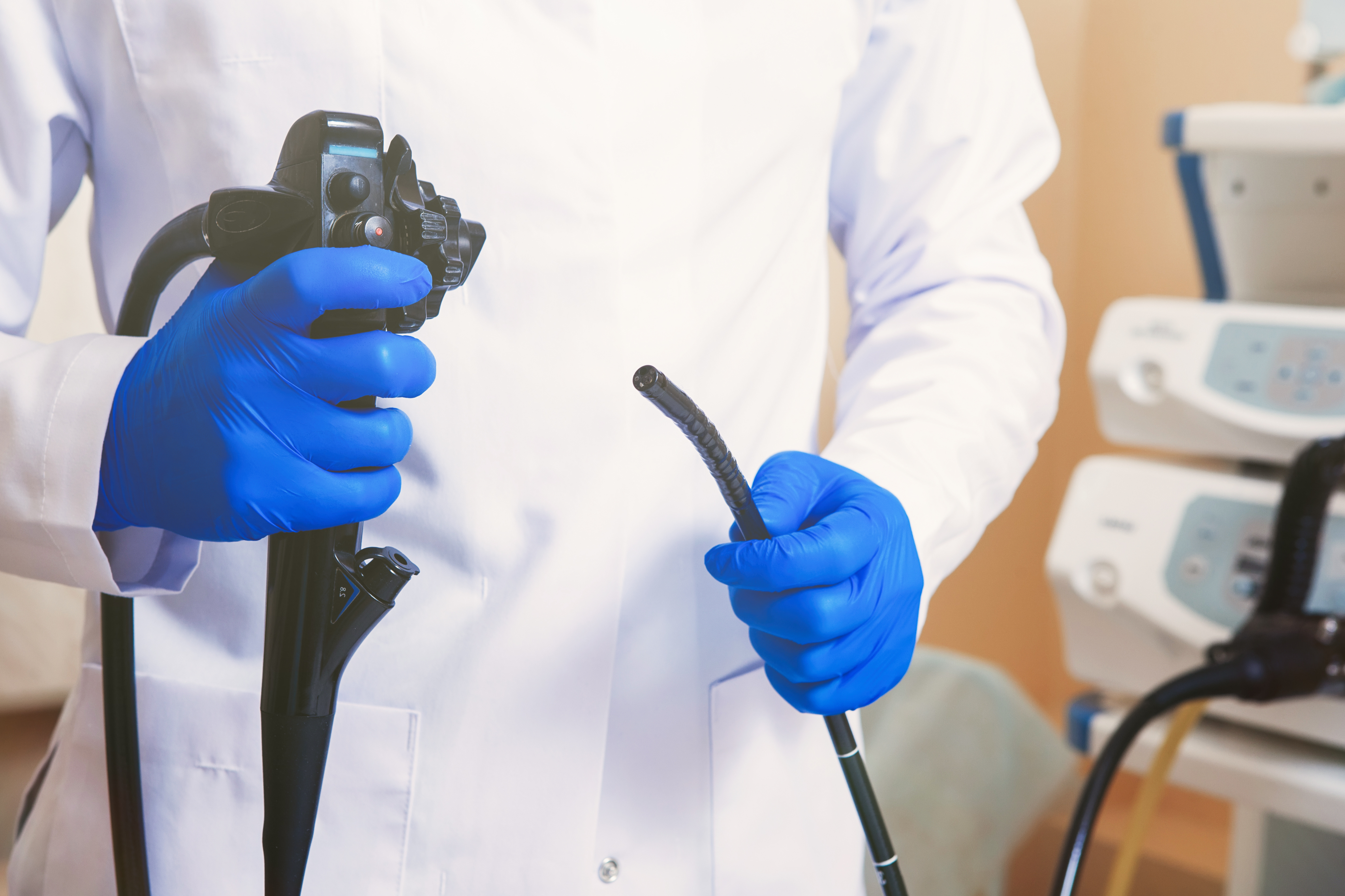 Doctor holding colonoscopy equipment during a consultation about the price of a colonoscopy in Singapore.