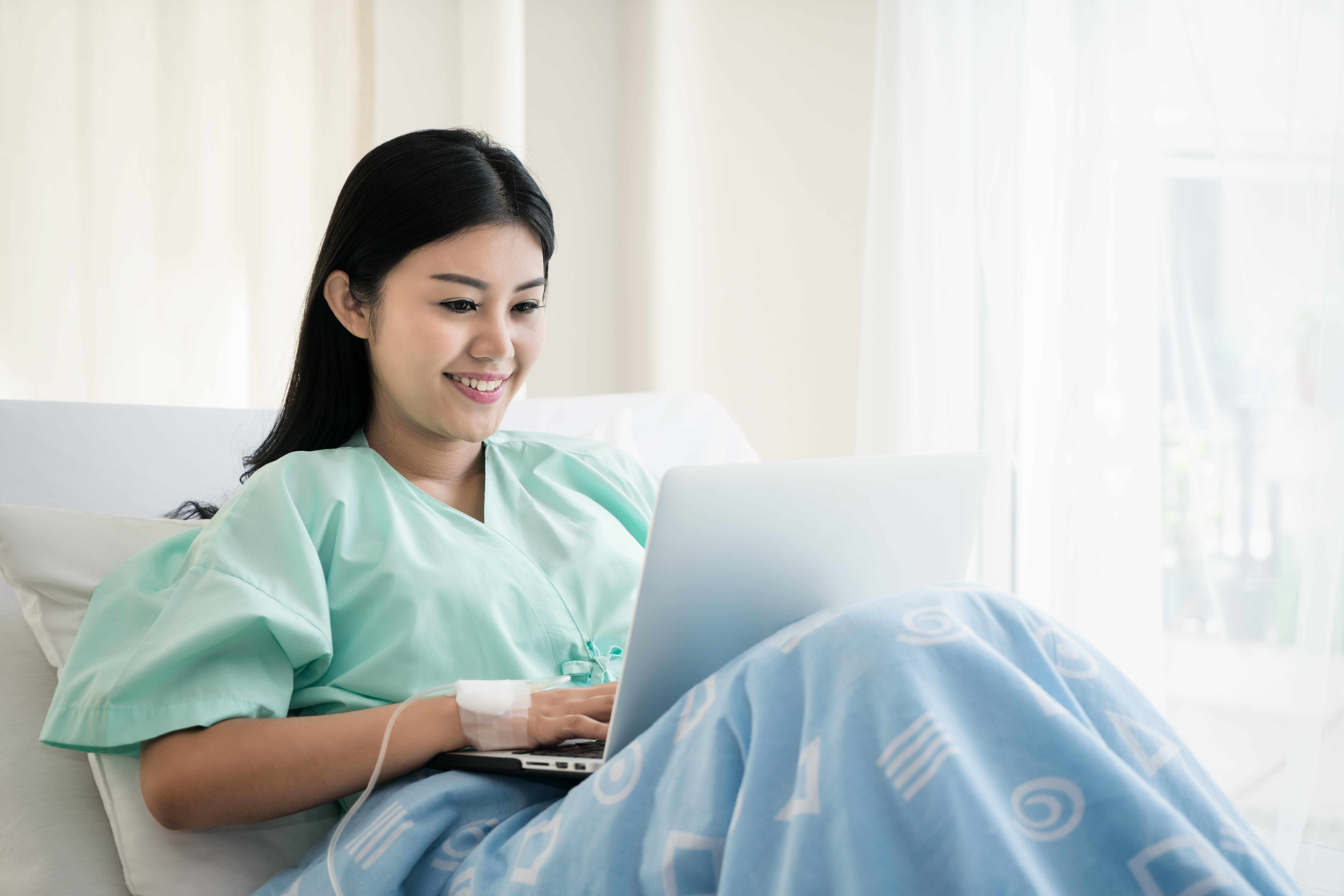 Patient using a laptop while preparing to visit a colonoscopy clinic in Singapore.